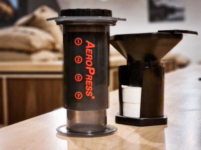 An aeropress coffee brewer with its accessories